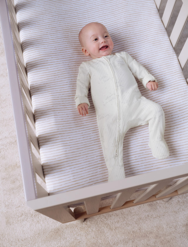 Baby lying in a bed.