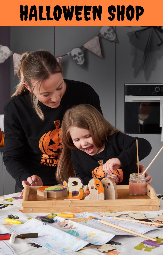 A woman and child wearing pumpkin sweaters.