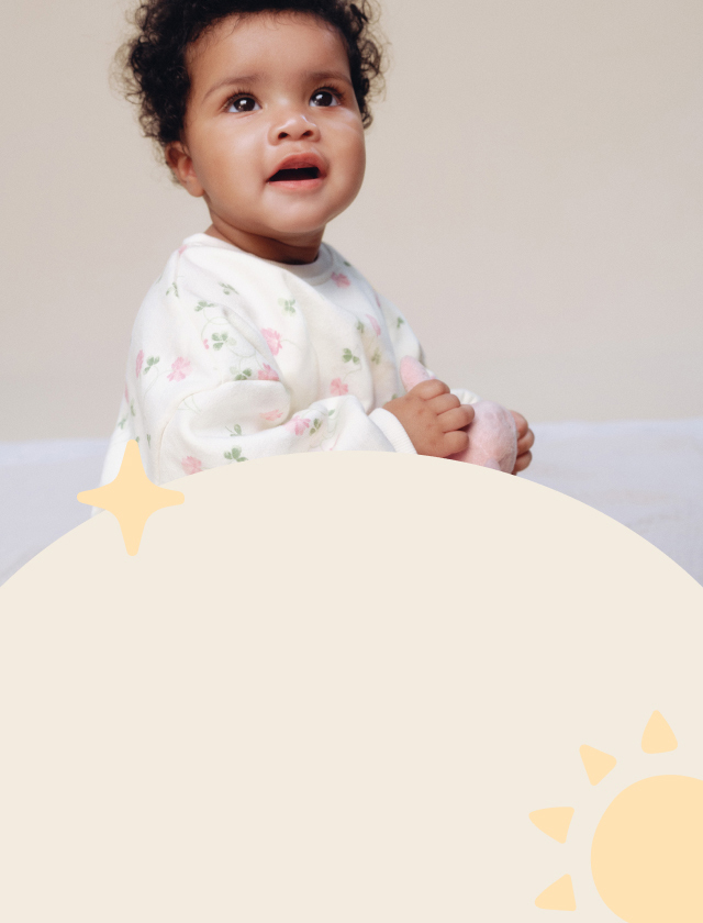 Baby holding a cuddly toy.