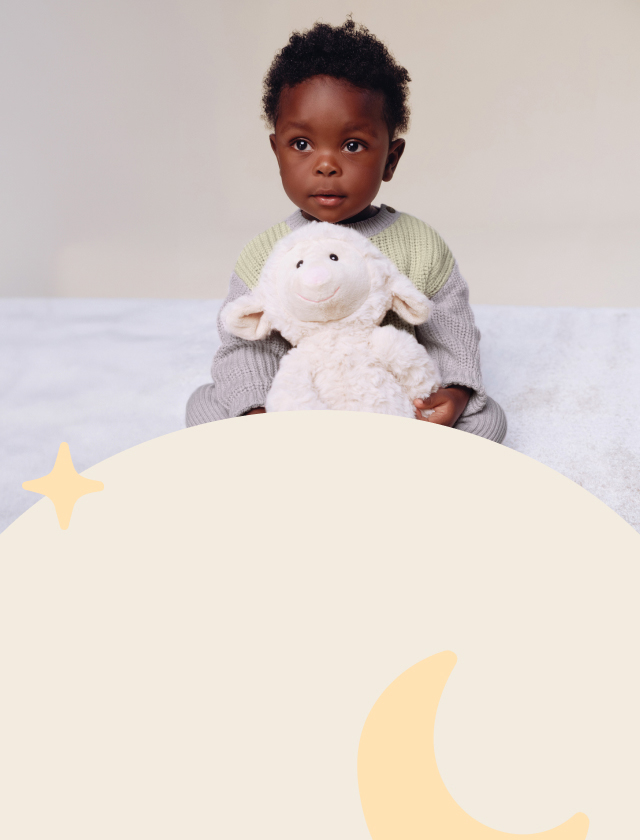 Baby holding a toy sheep.