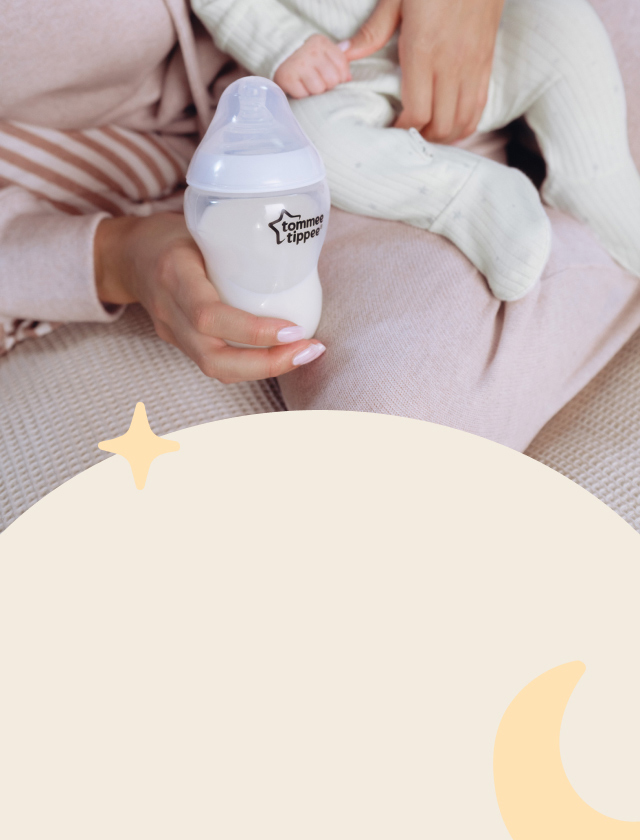 Woman holding a baby and bottle.